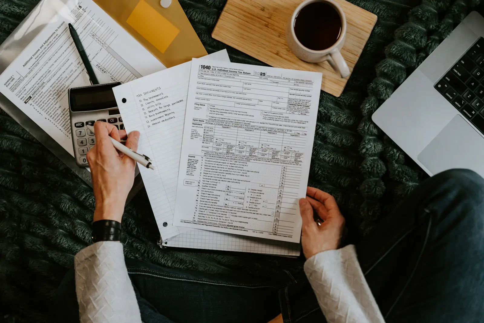 Person reviewing financial documents with a calculator